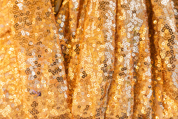 Sparkling golden fabric with sequins. Textured scales of round sequins with color transition .
