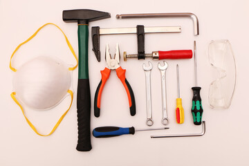 A set of new hand tools, mask, glasses and gloves on a white background.