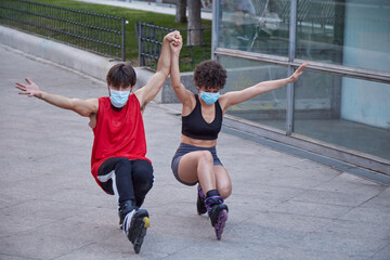 Couple skating on inline skates protected by face masks