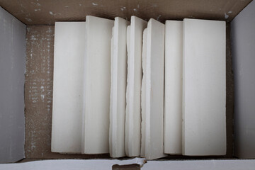 White gypsum brick for interior use in a cardboard box, top view.