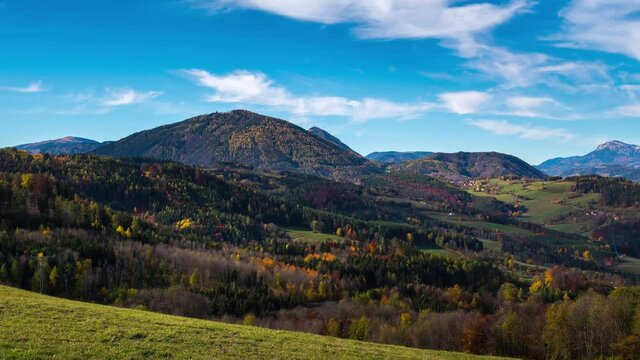 Moving timelapse in beautiful autumn scenary, mountains in the background, colorful trees and gras