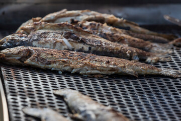 Whole and portioned fresh grilled fish for sale on the market.