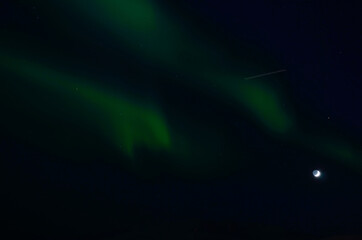 majestic aurora borealis dancing around full moon in winter night