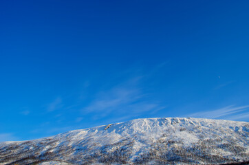 vibrant snowy mountain peak at sunrise on blue sky