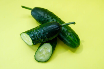 fresh summer vegetables, cucumbers, green cucumbers on a yellow background