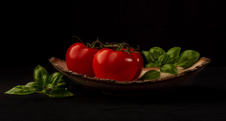 Frische Tomaten und Basilikum in Holzschale