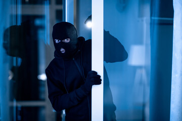 Thief breaking into apartment to steal, using torch
