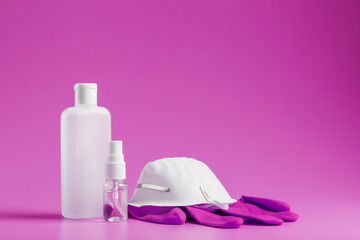 Fototapeta na wymiar Anti-virus protection kit on a pink background, mask, rubber gloves, bottles of hand sanitizer, antiseptic gel. Isolate