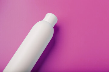White bottle on pink background. Free space for text.