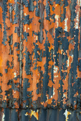 Old worn rusty corrugated steel texture on exterior wall.