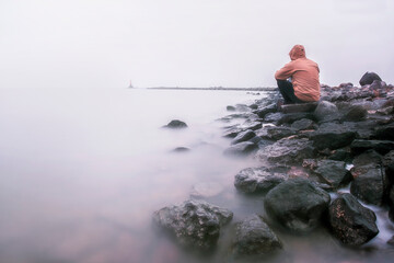 Fototapeta na wymiar lonely man on the shore of a foggy sea
