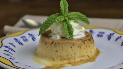 Flan de queso, postre tradicional español,  con nata montada y hojas de menta 