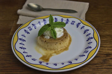 Flan de queso, postre tradicional español,  con nata montada y hojas de menta 