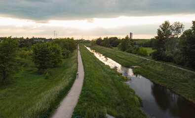 Obraz premium Path and river running to bright cloudy sunset