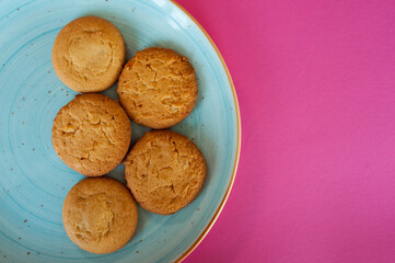 fresh sweet pastries. delicious shortbread cookies on a blue plate on a pink background