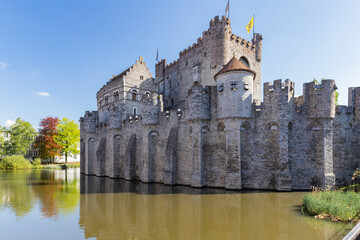 Obraz premium 10th-century medieval moated castle Gravensteen view with towers and flags in Ghent, Belgium