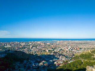 Landscape made from the mountain of Makhachkala city in Russia with a clear blue sky above the ocean without clouds.