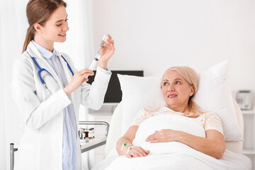 Female doctor working with patient in hospital room