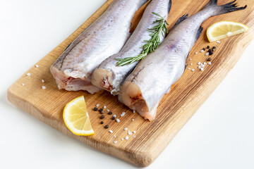Raw pollock fish on a board
