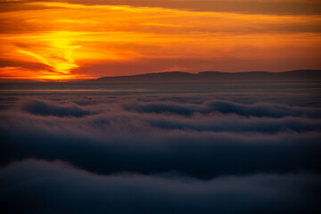 Fototapeta na wymiar Dreamy misty landscape above the sea of clouds, mountains at sunset in Iceland