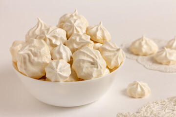 French meringue cookies in a bowl on white background