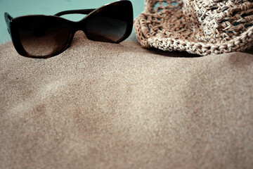 Fototapeta na wymiar Arena playa con gafas de sol y sombrero 