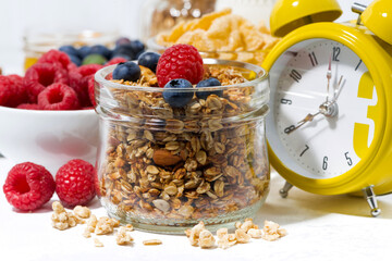 healthy products for breakfast, granola and berries on white table, closeup