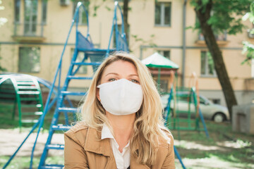 Fototapeta premium Young caucasian woman blonde hair in mask looking at camera