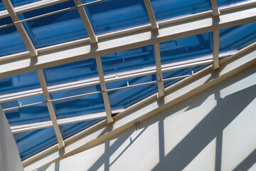Glass roof divided by white metal structures into squares