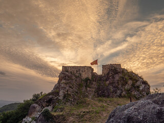 Fuerte antiguo con bandera en un amanecer