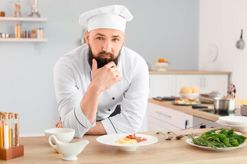 Portrait of handsome male chef in kitchen