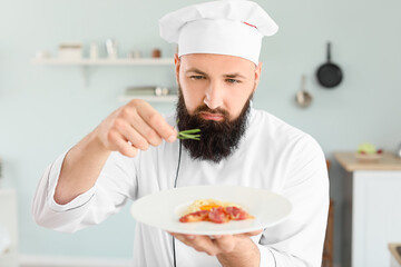Male chef with tasty pasta carbonara in kitchen