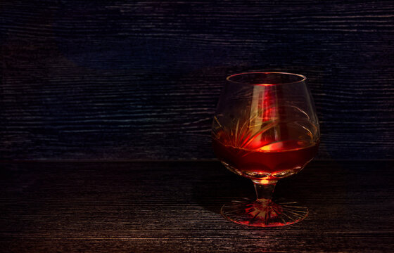 Glass with red wine on a black background.