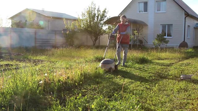 woman in backyard mowing grass lawn mower