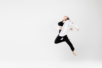 Female dancer in dance jazz poses in a jump on a white background. Jazz, modern, freedom, feelings, sport, figure, dance.