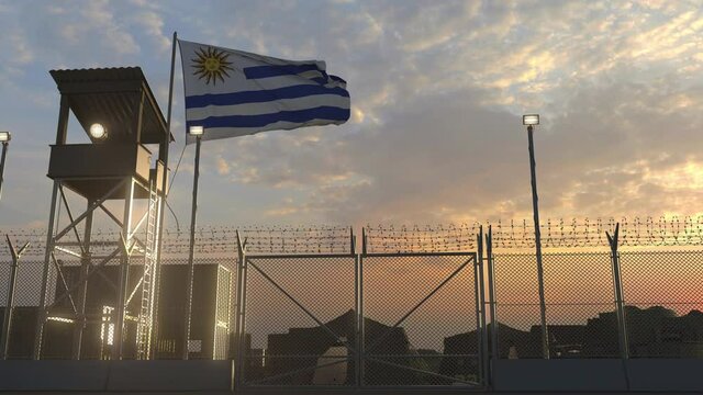 Waving flag of Uruguay above military base in the evening