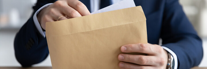 Horizontal panoramic view of businessman open envelope with postal paper letter in office, male...