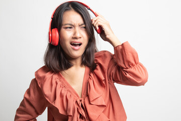 Too loud.  portrait of  young asian woman  holding  headphones and making unhappy face .