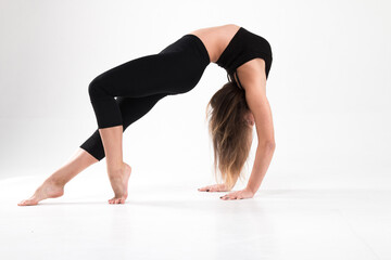 Girl in a gymnastic handstand with a bridge on a white background. Gymnastics, rhythmic gymnastics, practice, workout, strength, flexibility, stretching, performance.