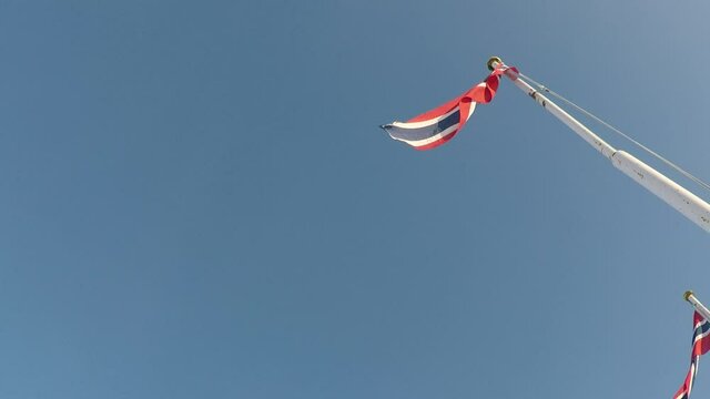 norwegian flag on pole on blue sky