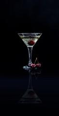 Closeup glass of sweet martini dry cocktail with cherries in black background