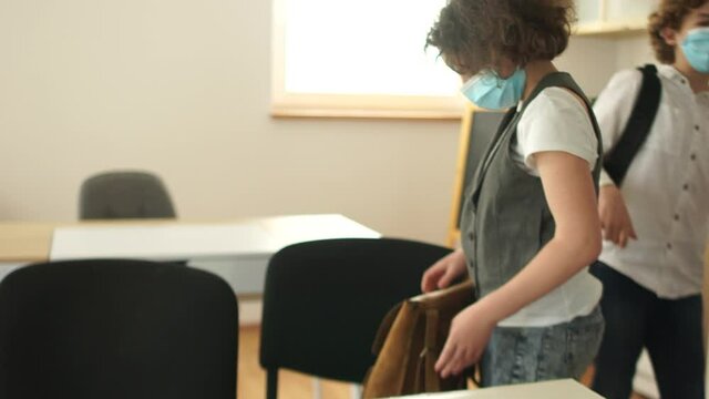 Studying in schools after quarantine. Back to school. Masked children leave the classroom after the lesson. Social distance, new normality