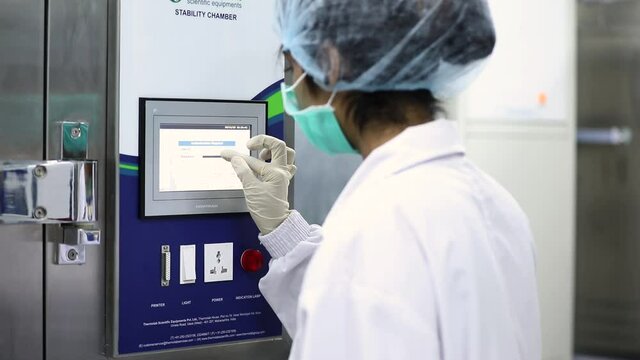A female enters password in stability chamber. Stability chamber for medicines.