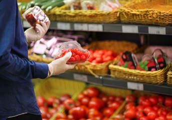 Supermarket shopping, face mask and gloves,man buying tomatoes at the market