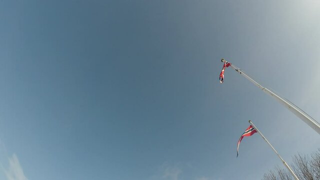 two norwegian flags on blue summer sky