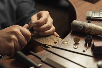 Bridal, marriage, wedding gold ring with diamonds. Close-up of a hand of a goldsmith polishing a precious jewel with shiny diamonds. To make the jewel it takes: precision, craftsmanship and patience.
