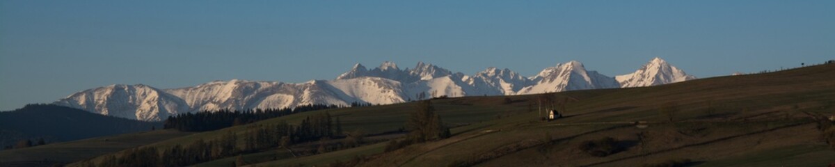 Early spring landscape with snowed Tatra Mountains and famous chapel in Kacwin, Malopolskie, Poland.