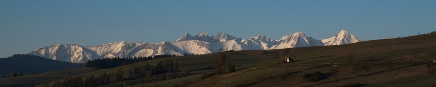 Early spring landscape with snowed Tatra Mountains and famous chapel in Kacwin, Malopolskie, Poland.