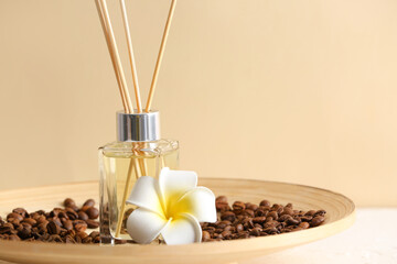 Plate with reed diffuser, coffee beans and flower on table