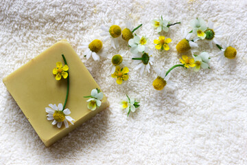 Handmade soap with medicinal herbs, flowers and a towel.